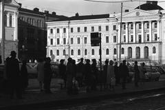 Aleksanterinkatu in Helsinki during rush hour with people at tram stop and Government Palace in the background