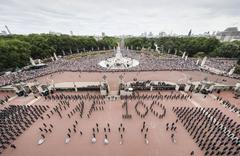 RAF personnel forming the 'RAF100' sign at Buckingham Palace with crowds on The Mall