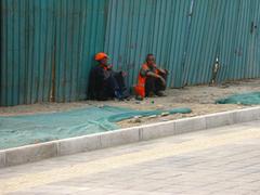 Two workers taking a rest beside a bicycle in China