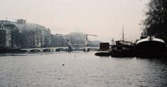 Scenic view of Amstel river in Amsterdam with boats and historic buildings