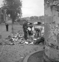 Groups of people searching for waste in Amsterdam streets during World War II