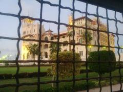 Rear view of a palace behind a wire fence