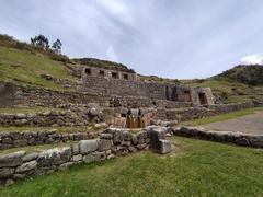 ancient stone ruins of Tambomachay in Peru with green hillside