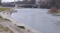 Stone steps at the northern tip of Weideninsel in Munich with Wittelsbacherbrücke in the background