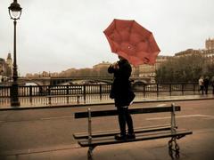 Young woman with red umbrella on Pont d'Arcole, Paris