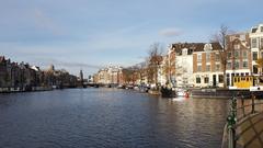 View of Amstel River with buildings along the riverbank and a scenic sky in 2020