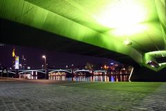 Ignatz-Bubis-Brücke and Frankfurt skyline at night, viewed from below Flößerbrücke