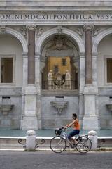 A biker passing by La Fontana Paola in Monte Gianicolo, Rome, Italy