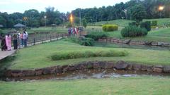 Japanese garden in Pune, India with a traditional wooden bridge over a pond and lush greenery