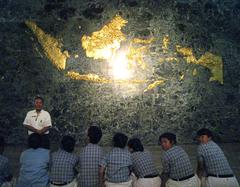 guide trainee students listening to instructor in front of golden Indonesian Archipelago Map