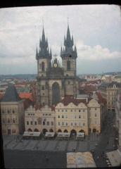 Historical church towers of the Týn Cathedral in Prague viewed through an old window