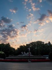 Fuente de Neptuno in Madrid during sunrise with a person running