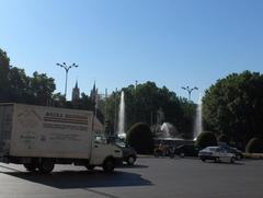 Panoramic view of a busy street in Madrid, Spain with pedestrians, vehicles, and historical buildings