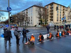 Letzte Generation blockade action at Luitpoldbrücke with TV team interviewing members, 2022