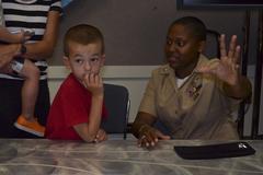 USS George H. W. Bush Sailor explains aircraft landing to student at George Bush Library