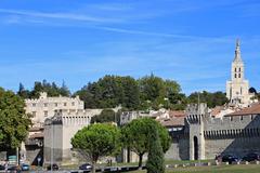 City walls of Avignon, France with Virgin Mary statue on cathedral tower in the background