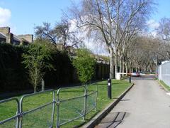 Service road in Geraldine Mary Harmsworth Park with houses in Brook Drive visible behind the wall