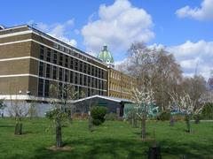 Side view of Imperial War Museum from Geraldine Mary Harmsworth Park with newly planted orchard trees