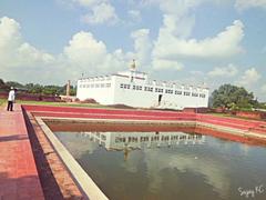 Lumbini area in Nepal with green fields, trees, and Buddhist monuments