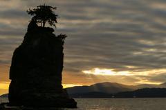 Sun rays over Siwash Rock in Stanley Park