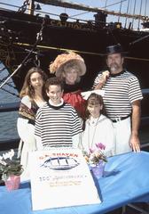 costumed Thayer family descendants pose behind CA THAYER's anniversary cake