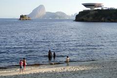 Niterói beach scene with blue sky and mountains in the background