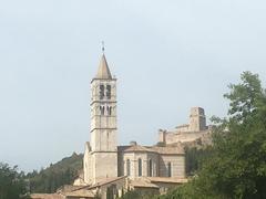 Scenic view of Assisi, Italy with historic buildings on a hillside under a blue sky