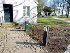 Heinesche Gartenhaus with cobblestone path and residential building in the background