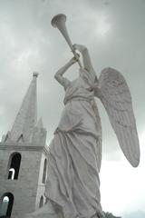 Angel blowing Trumpet with a tower in the background