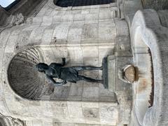 Fontaine Hubertus statue in Munich featuring a seated figure with a spear