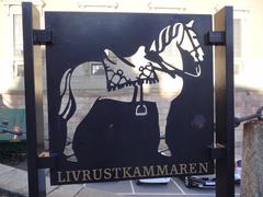 Entrance to the Royal Armoury Museum with the horse sign pointing towards the museum