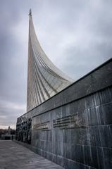 Space monument with a rocket sculpture on a pedestal against a blue sky