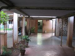 Hostel entrance with old computer room, scooter parking, and TV room in the background