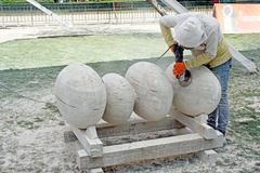 Sculptors working on stone sculptures outdoors at the 6th International Symposium of Sculpture Group in Parque de las Esculturas, Chile