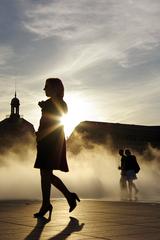 place de la bourse in Bordeaux at sunset with a girl walking in front of the water mirror