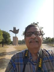 Person taking a selfie in front of the Hand sculpture in Chandigarh, India