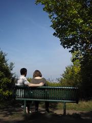 couple sitting on a bench at One Tree Hill in London