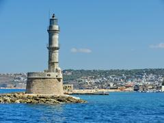 A picturesque view of the Chania harbor with traditional buildings and a lighthouse under a clear blue sky