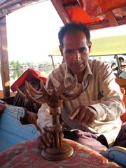 artisan selling wood carvings in a Shikara in Dal Lake, Srinagar, Kashmir