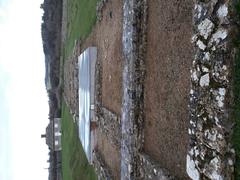 North Leigh Roman Villa ruins under a cloudy sky