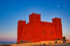 Red Tower in Mellieha photographed up close with a clear blue sky