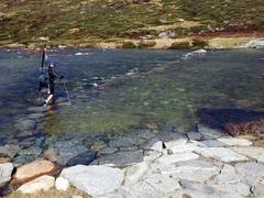 Skier crossing the upper Snowy River near Charlotte's Pass in spring