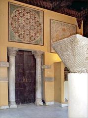 Exhibit hall of the Coptic Museum in Cairo featuring capitals and textiles