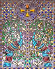 Coptic stained glass window with two facing peacocks