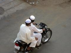 Two men riding a motorcycle on a street in India