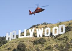 HH-65 Dolphin helicopter flying over Hollywood sign