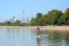 The Beaches waterfront in Greater Toronto Area with boardwalk, sandy beach, volleyball nets, and watercraft