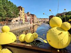 Façana del riu in Girona, with festive floral decorations on the Sant Feliu bridge.