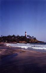 Serene beach at Kovalam with clear blue waters and palm trees lining the shore