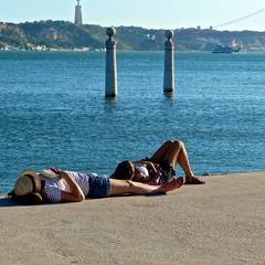 People enjoying the sun at Terreiro do Paço in Lisbon, Portugal